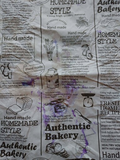 A picture of a kebab wrapper that appears to have been designed using "AI" and promotes the product as handmade, even though much of the text is complete nonsense.