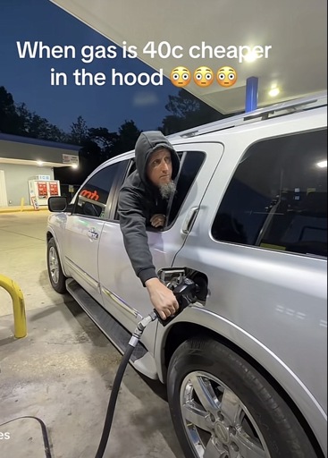 A photo of a man filling up his SUV by leaning out the backseat window while seated in the car with the caption “When gas is 40c cheaper in the hood”